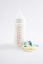 Vertical shot of a baby bottle next to a spoon on a milk powder pile Royalty Free Stock Photo