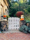 Vertical shot of a backyard gate decorated with stacked heirloom pumpkins for halloween