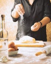 Vertical shot of a baker mixing the dough with flour