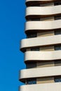 Vertical shot of the balconies of a residential modern building against blue sky