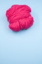 Vertical shot of a ball of pink yarn on a blue surface Royalty Free Stock Photo