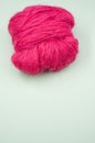 Vertical shot of a ball of pink yarn on a blue surface Royalty Free Stock Photo