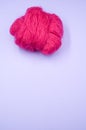 Vertical shot of a ball of pink yarn on a blue surface Royalty Free Stock Photo