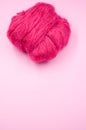 Vertical shot of a ball of pink yarn on a pink surface Royalty Free Stock Photo