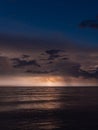 Vertical shot of Baltic sea at night with a flash of lightning in gloomy clouds with long exposure