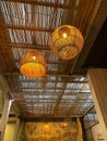 Vertical shot of bamboo pendant lamps hanging from a straw ceiling in a room Royalty Free Stock Photo