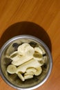 Vertical shot of banana slices in a metal plate on a wooden table with copy space. Top view of tropical fruits and healthy eating Royalty Free Stock Photo