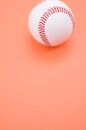 Vertical shot of a baseball ball isolated on coral background