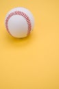 Vertical shot of a baseball ball isolated on yellow background