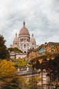 Vertical shot of The Basilica of the Sacred Heart of Paris or Sacre Coeur near a carousel in France