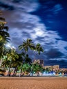 Vertical shot of a beach in Waikiki in Honolulu, Hawaii at night with long exposured clouds Royalty Free Stock Photo