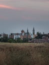 Vertical shot of a beautiful cityscape with a lot of old buildings near a grassy land Royalty Free Stock Photo