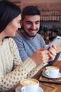 Beautiful couple using telephones at cafe