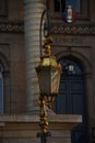 Vertical shot of a beautiful golden lamp in the street with a building in the background Royalty Free Stock Photo