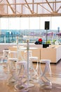 Vertical shot of a beautiful hall with white chairs, tables, and glass windows Royalty Free Stock Photo