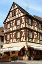 Vertical shot of beautiful house in Colmar with a nice cafe decorated by flowers, Alsace, France