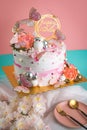 Vertical shot of a beautiful pink birthday cake decorated with butterflies Royalty Free Stock Photo