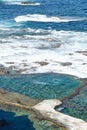 Vertical shot of a beautiful seawater pool in front of the rough Atlantic Ocean Royalty Free Stock Photo