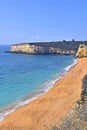 Vertical shot of a beautiful sunny beach with tall cliffs Royalty Free Stock Photo