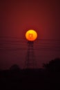 Vertical shot of a beautiful sunset with a silhouette of a transmission line tower. Royalty Free Stock Photo