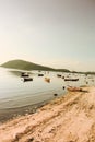 Vertical shot of a beautiful view of fishing boats in the sea near a sandy shore Royalty Free Stock Photo