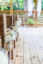 Vertical shot of a beautiful wedding venue with wooden chairs decorated with white flowers Royalty Free Stock Photo