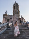 Vertical shot of a beautiful woman climbing stairs to the Church of Sant Bartomeu and Santa Tecla