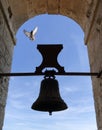 Vertical shot of a bell tower and a dove flying Royalty Free Stock Photo