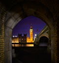 Vertical shot of the Big Ben from an arched shaped hallway at night Royalty Free Stock Photo