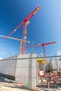 Vertical shot of big construction site with construction fence and cranes Royalty Free Stock Photo