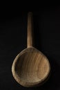 Vertical shot of a big wooden spoon isolated on black background Royalty Free Stock Photo