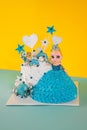 Vertical shot of a birthday cake in a form of a girl with a blue dress