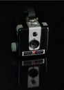 Vertical shot of a black vintage brownie hawkeye camera against a black background