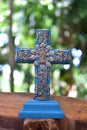 Vertical shot of a blue decorated cross on a wooden surface in a garden