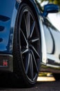 Vertical shot of a blue Hyundai Genesis Coupe luxurious car wheel with a sunbeam on the street