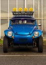 Vertical shot of a Blue Volkswagen Beetle with smiley lamps converted to a Beach Buggy