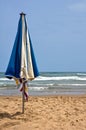 Vertical shot of a blue and white beach umbrella planted in the sand in Gandia, Valencia, Spain Royalty Free Stock Photo