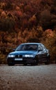 Vertical shot of BMW E46 320D with autumn trees in the background Royalty Free Stock Photo