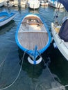 Vertical shot of a boat with a blue border docked in a harbor Royalty Free Stock Photo