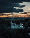 Vertical shot of a boat in a marsh at cloudy sunset. Richmond, Canada.