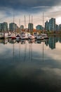 Vertical shot of the boats parked near the Coal Harbour in Vancouver with reflections in the water