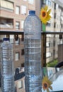 Vertical shot of bottles of water on a glass table on the balcony of the house Royalty Free Stock Photo