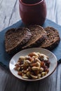 Vertical shot of a bowl of cashews and a cup next to the rye bread Royalty Free Stock Photo