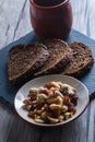 Vertical shot of a bowl of cashews and a cup next to the rye bread