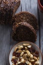 Vertical shot of a bowl of cashews next to rye bread