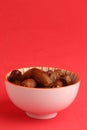 Vertical shot of a bowl of dates on a crimson background