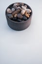 Vertical shot of a bowl filled with colorful rocks and pebbles Royalty Free Stock Photo