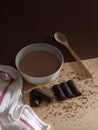 Vertical shot of a bowl of hot chocolate with a wooden spoon, a kitchen towel and chocolate pieces Royalty Free Stock Photo