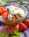 A vertical shot of bowl of jelly with cream and strawberries.