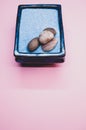 Vertical shot of a bowl of rocks on a pink surface Royalty Free Stock Photo